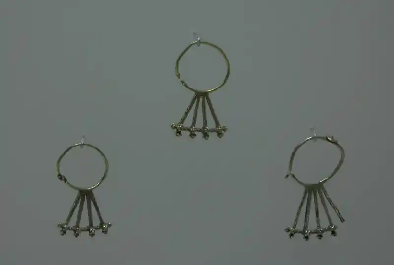Small spheres form crosses as pendants on an earring